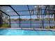 A screened-in pool overlooks a beautiful lake surrounded by lush greenery and mature trees at 23059 Geneva Rd, Land O Lakes, FL 34639