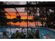 Screened-in pool with sunset view over the lake, creating a relaxing outdoor space at 23059 Geneva Rd, Land O Lakes, FL 34639