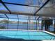 Inviting screened pool area with a picturesque lake view, perfect for relaxation at 23059 Geneva Rd, Land O Lakes, FL 34639