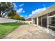 Expansive brick patio leads to a sunroom, bordered by a well-maintained lawn and white fencing at 2605 Durant Trails Blvd, Dover, FL 33527