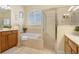 Well-lit bathroom featuring a soaking tub, glass-enclosed shower, and double vanity at 2605 Durant Trails Blvd, Dover, FL 33527
