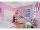 Pink bedroom featuring wood floors, a ceiling fan, closet and a window at 2605 Durant Trails Blvd, Dover, FL 33527
