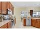 Traditional kitchen with wood cabinets, stainless steel appliances, and a view into the breakfast nook at 2605 Durant Trails Blvd, Dover, FL 33527