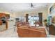 Warm living room with a kitchen view, leather seating, tile flooring, and backyard access at 2605 Durant Trails Blvd, Dover, FL 33527