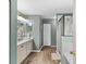 Bathroom with double sink vanity, stylish mirrors, and glass-enclosed shower at 3011 49Th S Ter, St Petersburg, FL 33712