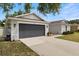 A charming single-story home featuring a well-maintained lawn, gray exterior, and a dark gray garage door at 3011 49Th S Ter, St Petersburg, FL 33712