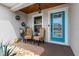 Inviting front porch with a light-wood ceiling, seating area, stone ground cover, and a stylish blue door at 3011 49Th S Ter, St Petersburg, FL 33712