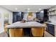 Open-concept kitchen with a large island, navy cabinets, and stainless-steel appliances. Seating provided at 3011 49Th S Ter, St Petersburg, FL 33712