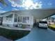 Inviting single-story home features an attached carport, well-maintained landscaping, and sunny skies at 34222 Canal N Dr, Pinellas Park, FL 33781