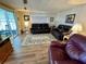 Living room features wood-look floors, sliders to the sunroom, and two sofas for gathering and relaxing at 34222 Canal N Dr, Pinellas Park, FL 33781