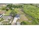 Aerial view of a white home with a gray roof and a large lawn next to a lush green wooded area at 38151 Sunset Ave, Dade City, FL 33525