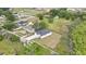 Aerial view of a white home with a gray roof and an expansive lawn and surrounding greenery at 38151 Sunset Ave, Dade City, FL 33525