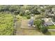 Aerial view of a white home with a black roof amid lush trees and greenery at 38151 Sunset Ave, Dade City, FL 33525
