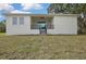 Exterior view of the backyard with a covered patio and steps leading down to the grass at 38151 Sunset Ave, Dade City, FL 33525