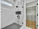 Beautiful bathroom with glass shower, gray hexagon tile flooring, and open closet with storage at 38151 Sunset Ave, Dade City, FL 33525