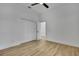Neutral bedroom with wood-look floors, ceiling fan, and double closet doors at 38151 Sunset Ave, Dade City, FL 33525