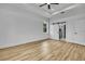 Bright bedroom with wood-look floors, a ceiling fan, and a sliding barn door to the bathroom at 38151 Sunset Ave, Dade City, FL 33525