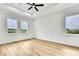 Bedroom with wood-look floors, modern ceiling fan and three windows providing natural light at 38151 Sunset Ave, Dade City, FL 33525