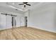 Bedroom featuring wood-look floors, a ceiling fan, and sliding barn doors to the closet at 38151 Sunset Ave, Dade City, FL 33525