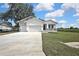 A cozy single-Gathering home featuring an attached two-car garage and green lawn at 38151 Sunset Ave, Dade City, FL 33525