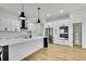 Bright kitchen features a large island, stainless steel appliances, white cabinets and modern pendant lighting at 38151 Sunset Ave, Dade City, FL 33525