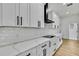 Modern kitchen with white cabinets, quartz countertops, subway tile backsplash, and stainless appliances at 38151 Sunset Ave, Dade City, FL 33525