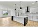 Modern kitchen with island, breakfast bar, quartz countertops, stainless appliances, and pendant lights at 38151 Sunset Ave, Dade City, FL 33525