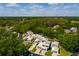 An aerial view of a community of townhomes, lush trees, a golf course, and a pond nearby at 4207 Fairway Run, Tampa, FL 33618