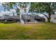 An exterior backyard shot with large screened-in patio, and well-maintained lawn at 4207 Fairway Run, Tampa, FL 33618