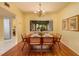 Bright dining room with hardwood floors, a decorative chandelier, and view to the front garden at 4207 Fairway Run, Tampa, FL 33618