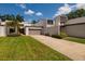 Modern home featuring a two-car garage, well-maintained lawn, and clean, white stucco facade at 4207 Fairway Run, Tampa, FL 33618