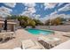A community pool featuring lounge chairs, a table, and an umbrella, surrounded by well-maintained landscaping at 4207 Fairway Run, Tampa, FL 33618