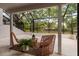 A relaxing screened patio featuring outdoor furniture with a view of the backyard and mature trees at 4207 Fairway Run, Tampa, FL 33618