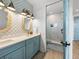 A well-lit bathroom with a double sink vanity, a tiled shower, and modern fixtures and calming blue accents at 4215 Saltwater Pearl Way, Cortez, FL 34215