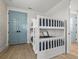 Charming bedroom with a white bunk bed and stylish light blue paneled doors at 4215 Saltwater Pearl Way, Cortez, FL 34215