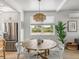 Dining area features a round wood table, white chairs, and ample natural light at 4215 Saltwater Pearl Way, Cortez, FL 34215