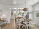 Bright dining room with a round wooden table, stylish chairs, and an open view into the modern kitchen at 4215 Saltwater Pearl Way, Cortez, FL 34215