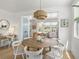 Bright dining area featuring a round wood table, white chairs, and stylish light fixture at 4215 Saltwater Pearl Way, Cortez, FL 34215
