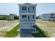 Charming three-story beach house with covered balconies and landscaped front yard, perfect for coastal living at 4215 Saltwater Pearl Way, Cortez, FL 34215