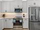 Close up of a modern kitchen with stainless steel appliances and white cabinets at 4215 Saltwater Pearl Way, Cortez, FL 34215
