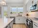 Modern kitchen with white cabinets, stainless steel appliances, and a view from the island at 4215 Saltwater Pearl Way, Cortez, FL 34215