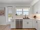 Bright kitchen features stainless steel dishwasher, white cabinets, and a large window over the sink at 4215 Saltwater Pearl Way, Cortez, FL 34215