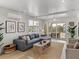 Cozy living room with a stylish blue sofa, white ceiling, and a sliding glass door leading to the balcony at 4215 Saltwater Pearl Way, Cortez, FL 34215
