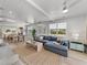 Open-concept living space with hardwood floors, a cozy sofa, and abundant natural light throughout the space at 4215 Saltwater Pearl Way, Cortez, FL 34215