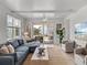 Bright living room with comfortable seating, ceiling fan, and sliding glass doors leading to an outdoor patio at 4215 Saltwater Pearl Way, Cortez, FL 34215