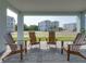 Charming covered patio with brick pavers and wooden chairs, offering serene outdoor living space at 4215 Saltwater Pearl Way, Cortez, FL 34215
