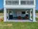 Inviting covered patio featuring brick pavers and comfortable wooden Adirondack chairs, perfect for relaxation at 4215 Saltwater Pearl Way, Cortez, FL 34215
