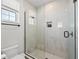 Modern shower with frameless glass doors, sleek fixtures, and recessed shelving, offering a spa-like experience at 4215 Saltwater Pearl Way, Cortez, FL 34215
