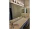 Bright bathroom featuring a double vanity and an oversized mirror at 607 Manchester Woods Dr # 84, Sun City Center, FL 33573