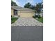 Paver driveway leading to the front of a one story home and two-car garage at 607 Manchester Woods Dr # 84, Sun City Center, FL 33573